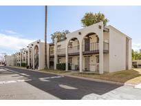 Charming apartment complex featuring a desert color scheme and exterior staircases for upper-level units at 131 N Higley Rd # 215, Mesa, AZ 85205