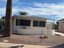 Cozy home featuring a covered patio and low-maintenance landscaping with desert accents, offering comfortable outdoor living at 2207 N Shannon Way, Mesa, AZ 85215