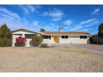 Charming single-story home features a vibrant yellow door and well-manicured landscaping, complete with a large driveway at 3716 W Griswold Rd, Phoenix, AZ 85051