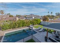 Aerial shot of a backyard with a pool, patio, and green space, with mountain views at 4306 E Flower St, Phoenix, AZ 85018