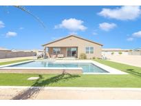 Stunning backyard featuring a sparkling in-ground pool and lush artificial turf, perfect for outdoor entertaining at 4507 E Warlander Ln, San Tan Valley, AZ 85140