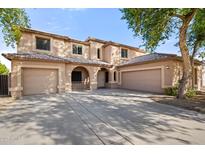 Inviting two-story home showcasing a three-car garage and a charming front entrance with arched accents at 5422 W Bryce Ln, Glendale, AZ 85301