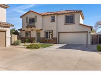 Two-story home featuring a neutral stucco exterior, red tile roof, well-kept lawn, and an attached two-car garage at 681 E Los Arboles Pl, Chandler, AZ 85225