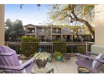 Outdoor patio with purple Adirondack chairs overlooking a serene waterfront and nearby buildings at 705 W Queen Creek Rd # 1157, Chandler, AZ 85248