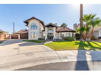 Charming two-story stucco home featuring a red tile roof, manicured lawn and circular driveway at 901 E Scott Ave, Gilbert, AZ 85234