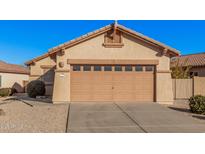 Beige stucco home featuring a large garage with attractive detailing above the door and a low maintenance yard at 10352 E Second Water Trl, Gold Canyon, AZ 85118