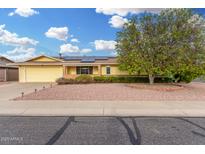 Charming single-story home featuring yellow paint, solar panels, and a low maintenance front yard at 10414 W Ponderosa Cir, Sun City, AZ 85373