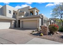 Elegant home featuring a spacious three-car garage, desert landscaping, and a charming stone mailbox post at 14850 E Grandview Dr # 226, Fountain Hills, AZ 85268