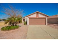 Charming single-story home with a well-manicured yard and a two-car garage at 14946 W Caribbean Ln, Surprise, AZ 85379