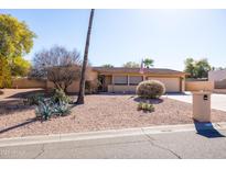 Charming single-story home features desert landscaping, a two-car garage, and an American flag at 17217 E Calaveras Ave, Fountain Hills, AZ 85268