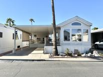 Charming manufactured home with a covered carport and a cozy front porch at 177 S Limestone Dr, Apache Junction, AZ 85119