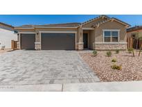 Charming single-Gathering home with a well-manicured front yard and a paved driveway leading to a two-car garage at 18192 W Ashley Dr, Goodyear, AZ 85338