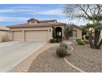 Charming single-story home with a three-car garage, desert landscaping, and a paved walkway leading to the entrance at 23731 S Angora Dr, Sun Lakes, AZ 85248