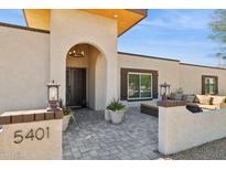 Charming home featuring a covered entryway and a welcoming outdoor seating area at 5401 E Corrine Dr, Scottsdale, AZ 85254