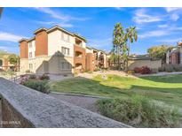 Beautiful building exterior with landscaped grounds and a sunny, clear sky at 5401 E Van Buren St # 1068, Phoenix, AZ 85008