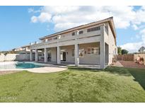 Spacious backyard features a large patio, artificial grass, and a refreshing pool at 7318 W Paso Trl, Peoria, AZ 85383