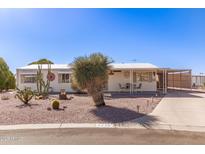 Charming home featuring desert landscaping, covered porch, and a convenient carport at 8233 E Calypso Ave, Mesa, AZ 85208