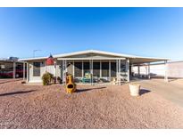 Charming single-story home featuring a covered porch, carport, and low-maintenance desert landscaping at 8258 E Calypso Ave, Mesa, AZ 85208