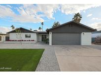 Charming single-story home featuring a two-car garage, manicured lawn, and fresh landscaping at 3117 E Sweetwater Ave, Phoenix, AZ 85032