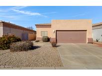 Single-Gathering home features a two car garage, desert landscaping, and neutral paint at 6392 W Pontiac Dr, Glendale, AZ 85308