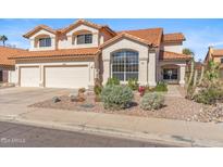 Charming two-story home with a well-manicured front yard, desert landscaping, and a three car garage at 9102 E Pershing Ave, Scottsdale, AZ 85260