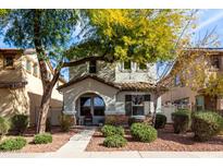 Charming two-story home with desert landscaping, arched porch, and stone accents at 1042 S Cheshire Ln, Gilbert, AZ 85296