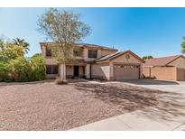 Two-story home showcasing a front yard with desert landscaping and a large attached two-car garage at 1114 S Grenoble --, Mesa, AZ 85208