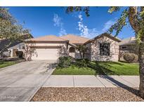 Charming single-story home with a well-maintained lawn and two-car garage in a desirable neighborhood at 13594 W Port Royale Ln, Surprise, AZ 85379