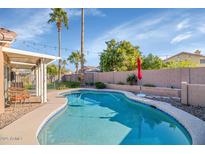 Relaxing pool with a red umbrella, lounge chairs, and landscaped backyard perfect for outdoor enjoyment at 1363 N Mckenna Ln, Gilbert, AZ 85233