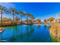 Beautiful community pond with palm trees and fountain feature reflecting on the water in the sunlight at 1664 E Bridgeport Pkwy, Gilbert, AZ 85295