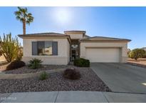 Charming single-story home with desert landscaping, lush greenery, and a two-car garage at 17697 W Sunbelt Dr, Surprise, AZ 85374