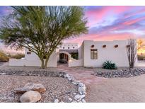 Charming southwestern home featuring a stucco exterior, desert landscaping, and beautiful stone walkway at 19927 W Meadowbrook Ave, Litchfield Park, AZ 85340