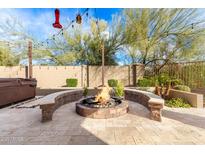 Inviting backyard featuring a stone fire pit with seating and mature landscaping at 22905 N 19Th Way, Phoenix, AZ 85024