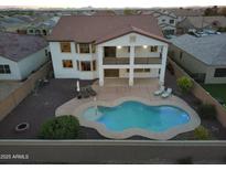 Aerial view of the backyard featuring a large pool with patio seating and a covered balcony at 30402 W Vale Dr, Buckeye, AZ 85396