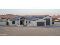 Stunning single-story home featuring a three-car garage, desert landscaping, and a mountain view at 37937 N 31St Ave, Phoenix, AZ 85086