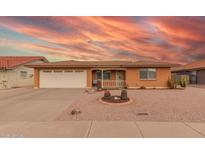 Charming single-story brick home featuring a desert-style landscape and a spacious two-car garage at 8012 E Monte Ave, Mesa, AZ 85209