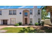 Charming two-story home featuring stucco siding, a terracotta roof, a manicured lawn, and a stylish front door at 111 W Missouri Ave # E, Phoenix, AZ 85013