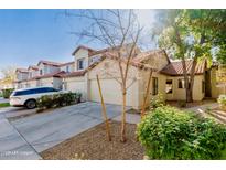 Charming townhome featuring a stucco exterior, red tile roof, and a well-maintained front yard with mature landscaping at 1157 W Edgewater Dr, Gilbert, AZ 85233