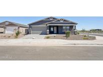 Charming single-story home with a well-manicured front yard and a two-car garage at 15762 W Cheryl Dr, Waddell, AZ 85355