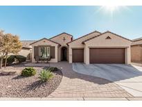 Charming home featuring a desert landscape, a brick walkway, and a three-car garage at 16713 W Monte Vista Rd, Goodyear, AZ 85395