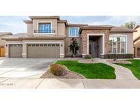 Inviting two-story home featuring a manicured lawn, stone accents, and an attached three-car garage at 21732 N 86Th Ln, Peoria, AZ 85382