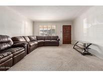 Inviting living room with a large, comfortable brown leather sectional sofa and bright, natural light at 2806 W Marshall Ave, Phoenix, AZ 85017