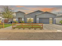 Charming home exterior with a well-manicured lawn, modern gray paint, and a wood fence at 3007 N 47Th St, Phoenix, AZ 85018