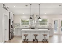 Bright kitchen with gray cabinets, stainless steel appliances, an island, and decorative backsplash at 3007 N 47Th St, Phoenix, AZ 85018