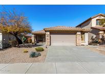 Charming single-story home featuring a tile roof, stone accents, desert landscaping, and a two-car garage at 3650 W Denali Dr, Anthem, AZ 85086