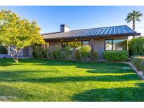 Well-maintained home with a lush green lawn, mature landscaping, and a modern architectural style at 3931 E Glenrosa Ave, Phoenix, AZ 85018