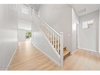 Bright hallway features wood floors, white walls, staircase, and views to the backyard at 550 W Copper Way, Chandler, AZ 85225