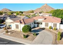 Beautiful single-story home with a red tile roof, mature landscaping, and circular driveway in a mountain backdrop community at 6014 W Bent Tree Dr, Phoenix, AZ 85083