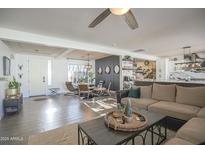 Open-concept living room with neutral tones and modern design flows into the dining and kitchen areas at 6014 W Bent Tree Dr, Phoenix, AZ 85083