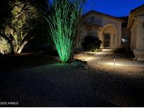 Charming home exterior at night, showcasing landscape lighting and a welcoming entrance at 11115 E Bellflower Ct, Sun Lakes, AZ 85248